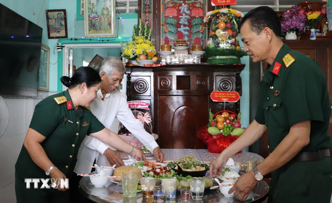 Cán bộ, chiến sỹ lực lượng vũ trang thành phố Cần Thơ cùng gia đình Mẹ Việt Nam anh hùng Trần Thị Hai (phường Hưng Phú) chuẩn bị mâm cơm tri ân liệt sỹ. (Ảnh: Hồng Thái/TTXVN) ttxvn-tron-nghia-tinh-mam-com-tri-an-liet-si-8172767.jpg