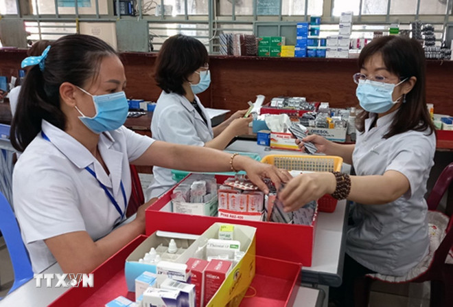 Nhân viên y tế chuẩn bị thuốc để cấp cho bệnh nhân. (Ảnh: Xuân Triệu/TTXVN) ttxvn-thuoc-cap-cho-benh-nhan-dieu-tri-ngoai-tru-6012716.jpg