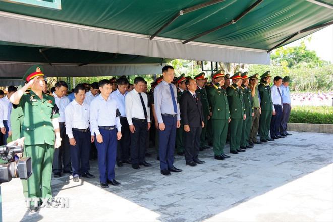 Các đại biểu mặc niệm tưởng nhớ công lao to lớn của các anh hùng, liệt sỹ. (Ảnh: TTXVN phát) ttxvn-quang-binh-truy-dieu-va-an-tang-17-hai-cot-liet-si-8045210.jpg