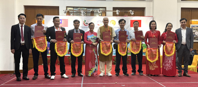 លោកវេជ្ជបណ្ឌិត ផាម វ៉ាន់ ថាង (ទីមួយរាប់ពីឆ្វេង) និងលោកស្រី ត្រឹន ធីឆាង (ទីប្រាំរាប់ពីឆ្វេង) បានប្រគល់ទង់ជាតិរំលឹកដល់បុគ្គលឆ្នើមៗនៅក្នុងកម្មវិធី។ (រូបថត៖ វៀនលឿញ/VNA) giao-luu-van-hoa-viet-nam-malaysia-ket-noi-truyen-thong-lan-toa-gia-tri-asean-8471147.jpg