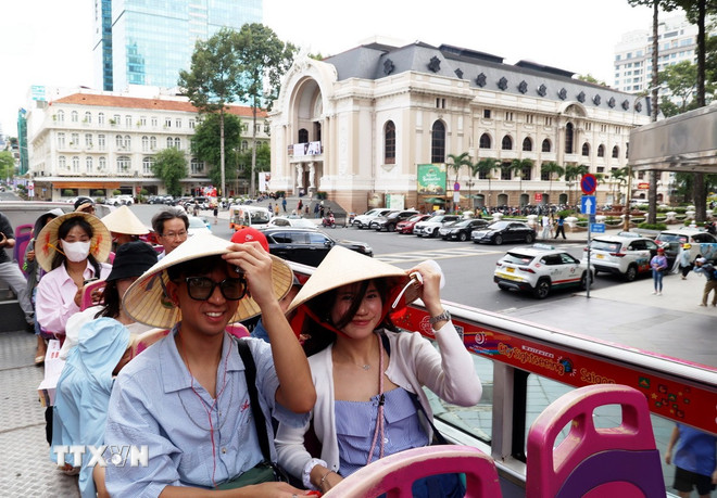 Nón lá truyền thống Việt Nam được khách quốc tế sử dụng nhiều khi tham quan Thành phố Hồ Chí Minh. (Ảnh: Hồng Đạt/TTXVN) ttxvn-du-khach-6-thang-nam-2025-813245.jpg