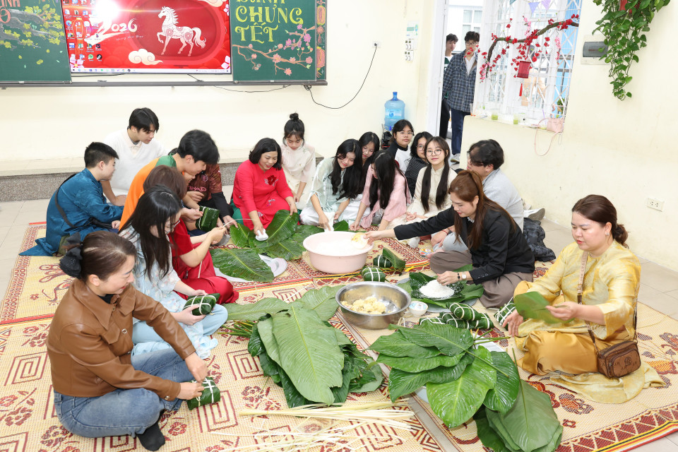 Do không gian sân trường khá chật và để dành cho hoạt động hội xuân nên việc thi gói bánh chưng diễn ra ngay trong các lớp học. (Ảnh: PV/Vietnam+)