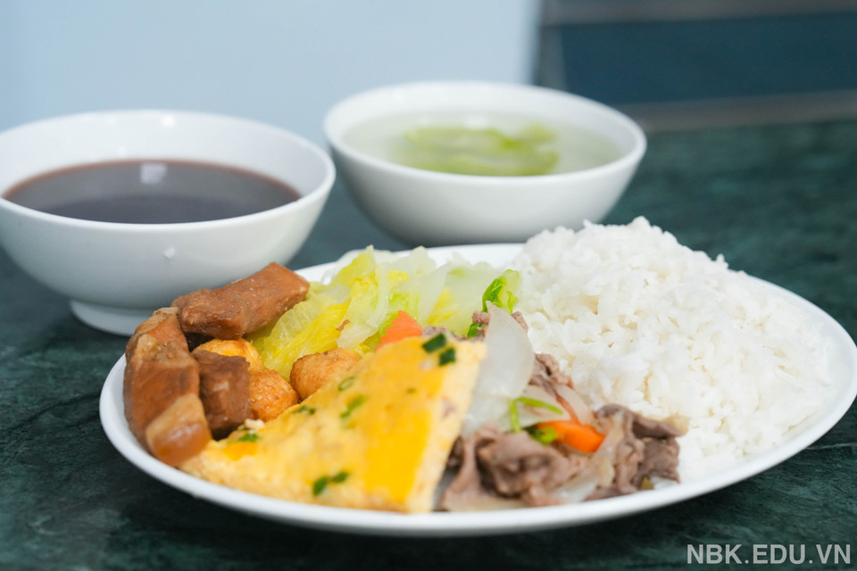 Bữa cơm tối của các em học sinh đầy đủ như bữa ăn bán trú. (Ảnh: Nhà trường cung cấp/Vietnam+)