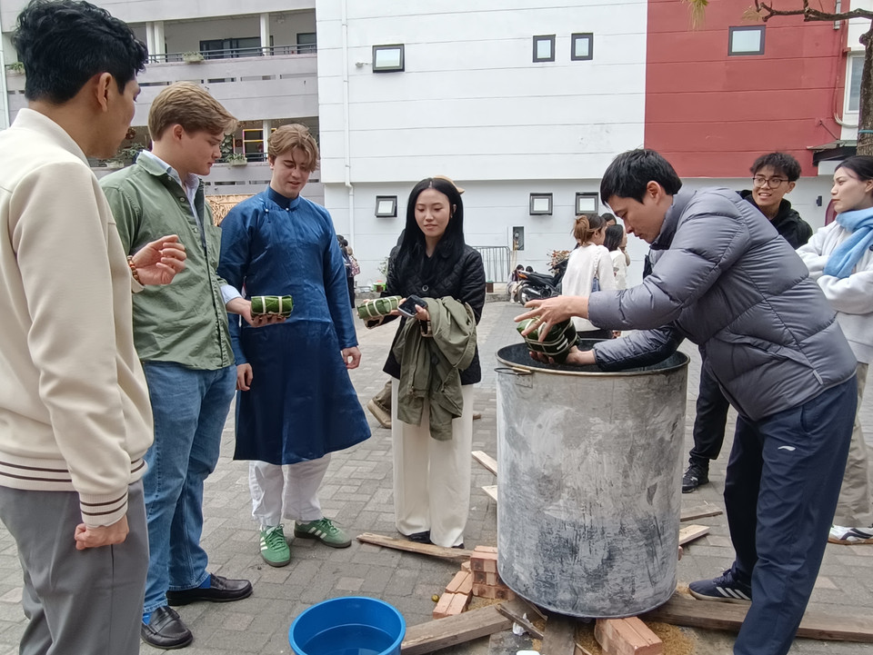 ... và háo hức chờ luộc bánh chưng. (Ảnh: PV/Vietnam+)