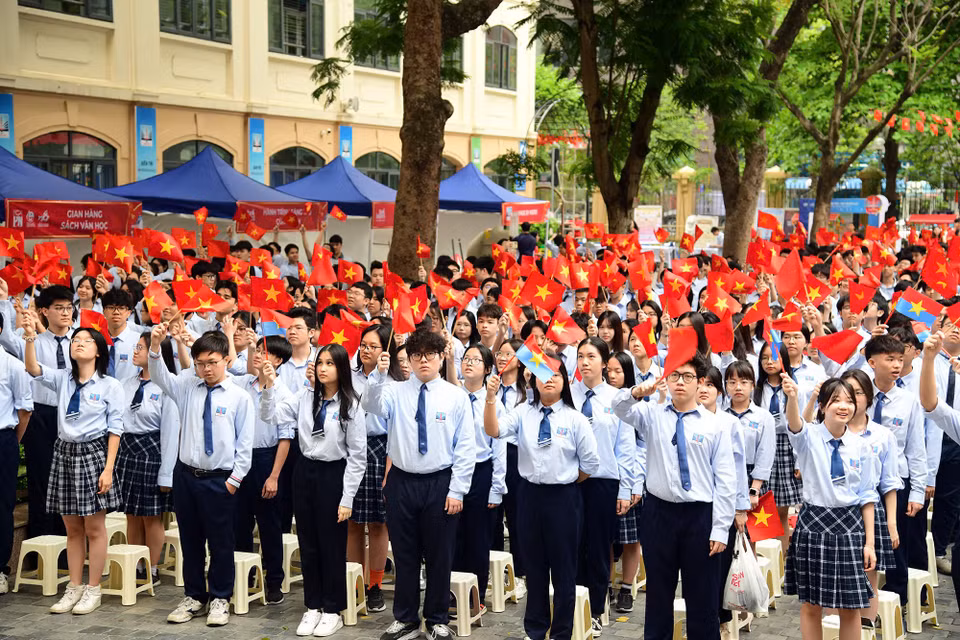 Các em học sinh với lá cờ Tổ quốc và cờ của Mặt trận Dân tộc giải phóng miền Nam Việt Nam. (Ảnh: PV/Vietnam+)