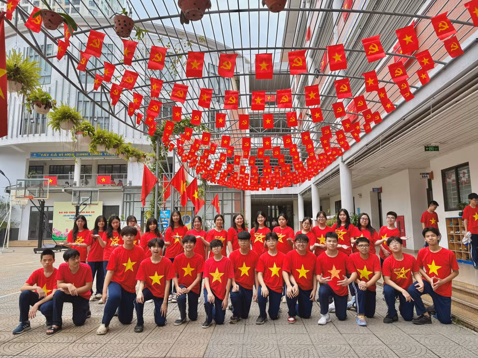 Học sinh hào hứng hưởng ứng cuộc phát động treo cờ Tổ quốc và mặc áo cờ đỏ sao vàng. (Ảnh: PV/Vietnam+)