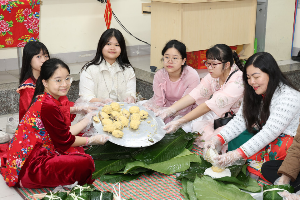 Học sinh hào hứng khi được thầy cô, phụ huynh hướng dẫn tham gia các công đoạn, tự tay gói bánh... (Ảnh: PV/Vietnam+)