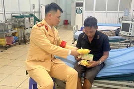 Chiến sĩ Cảnh sát giao thông chăm sóc ông Thắng tại bệnh viện Đan Phượng (Nguồn: Bộ Công an)