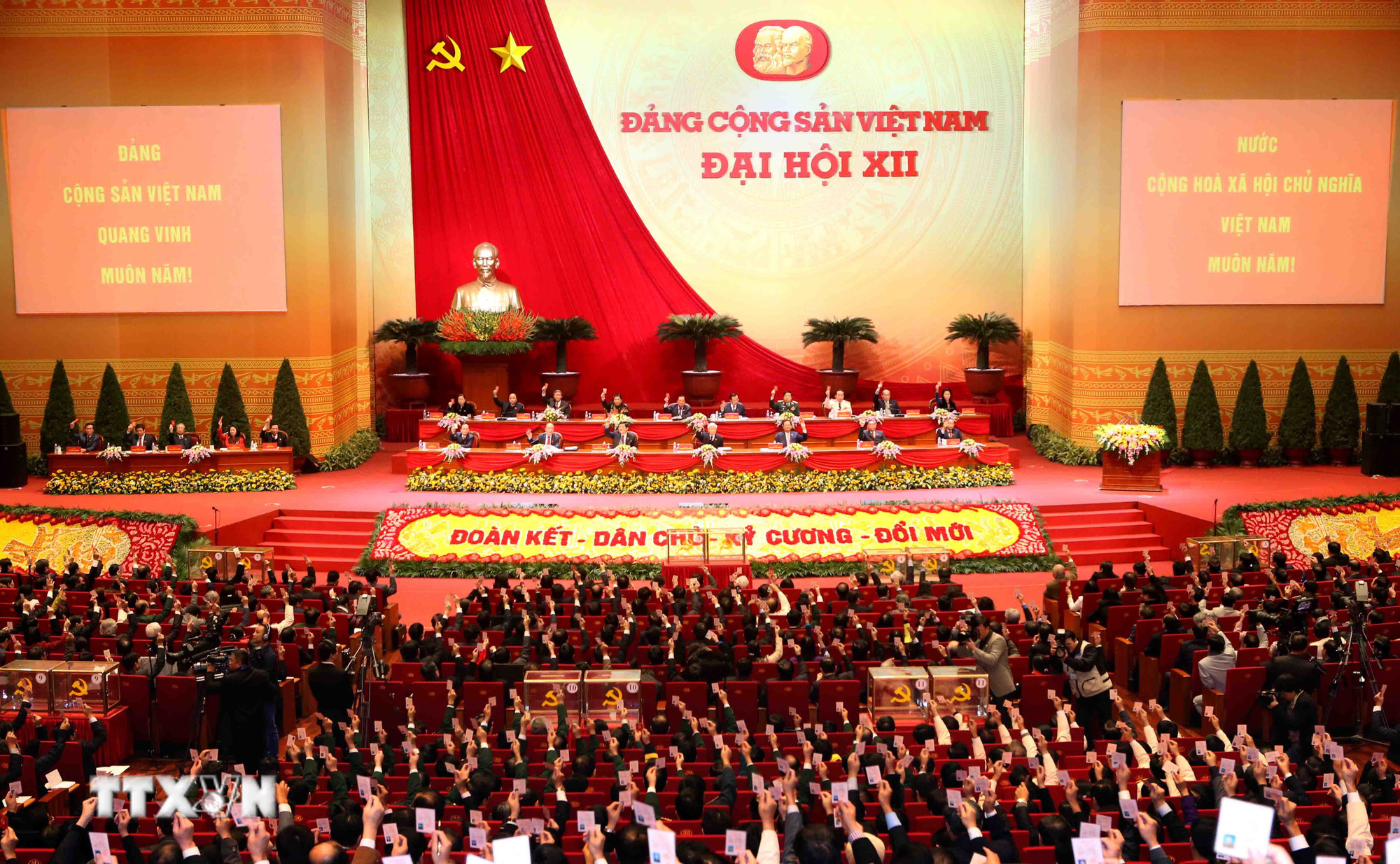 Các đại biểu biểu quyết kết quả bầu Ban Chấp hành Trung ương Đảng khóa XII. (Ảnh: TTXVN)