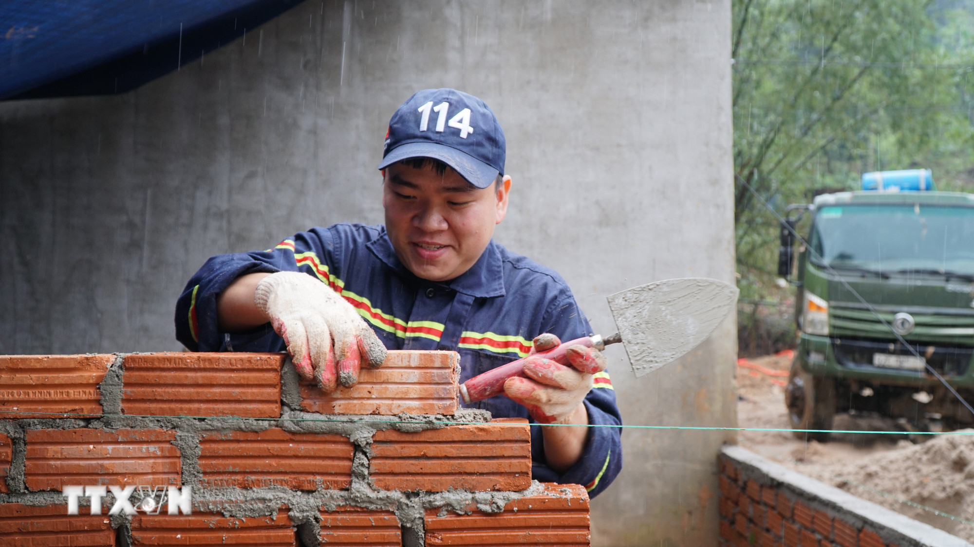 Trung úy Bùi Quang Vinh, Phòng Cảnh sát Phòng cháy, chữa cháy và cứu nạn, cứu hộ (Công an thành phố Đà Nẵng) tham gia xây nhà cho bà con bị ảnh hưởng của bão lũ tại xã Nam Trà My, thành phố Đà Nẵng. (Ảnh: Quốc Dũng/TTXVN)