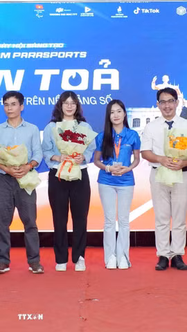 Ban tổ chức tặng hoa tới các diễn giả tham gia Ngày hội sáng tạo Vietnam ParaSports với chủ đề "Lan tỏa dấu ấn cá nhân trên nền tảng số". (Ảnh: Trung Tuyến/TTXVN)