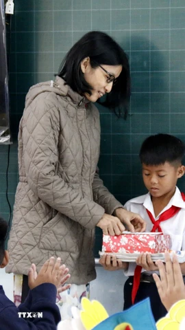 Cô giáo chủ nhiệm trao quà cho em Nguyễn Anh Tín, học sinh lớp 5D Trường tiểu học Lâm Hưng, bị thiệt hại nặng do mưa lũ. (Ảnh: Hồng Hiếu/TTXVN)