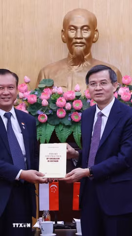 Đồng chí Đoàn Minh Huấn, Ủy viên Bộ Chính trị, Giám đốc Học viện Chính trị quốc gia Hồ Chí Minh tặng cuốn sách của cố Tổng Bí thư Nguyễn Phú Trọng cho ông Lee Hong Chuang, Trưởng Nghị sỹ Quốc hội Singapore, Trưởng Nhóm Nghị sỹ Quốc hội khu vực Jurong East-Bukit Batok GRC. (Ảnh: Văn Điệp/TTXVN)