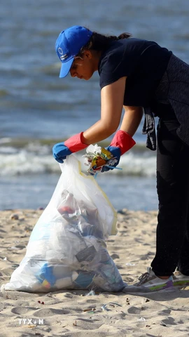 Tình nguyện viên dọn rác trên bãi biển ở Alexandria, Ai Cập. (Nguồn: THX/TTXVN)
