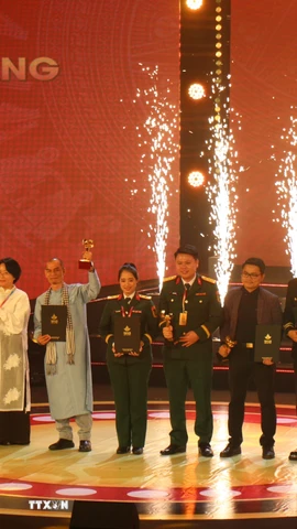 Thứ trưởng Bộ Văn hóa, Thể thao và Du lịch Tạ Quang Đông và Phó Trưởng ban Thường trực Ban Tuyên giáo và Dân vận Trung ương Lại Xuân Môn trao giải thưởng Bông sen Vàng. (Ảnh: Thu Hương/TTXVN)