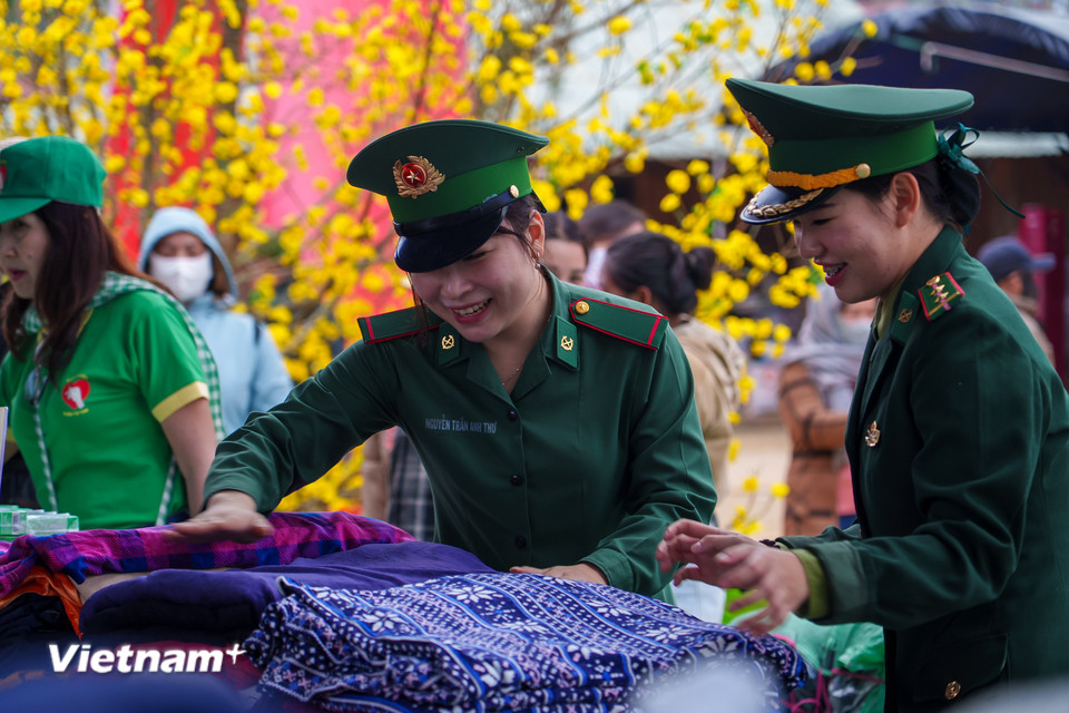Các nữ quân nhân hỗ trợ bà con chọn quần áo ấm, chăn màn để chống chọi với cái lạnh sương muối vùng cao. (Ảnh: Thanh Phong/Vietnam+)