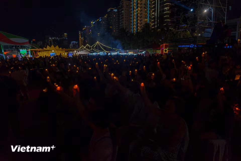 Hàng ngàn khán giả hòa mình vào không khí sôi động, thắp sáng đêm hội bằng ánh đèn. (Ảnh: Thanh Phong/Vietnam+)