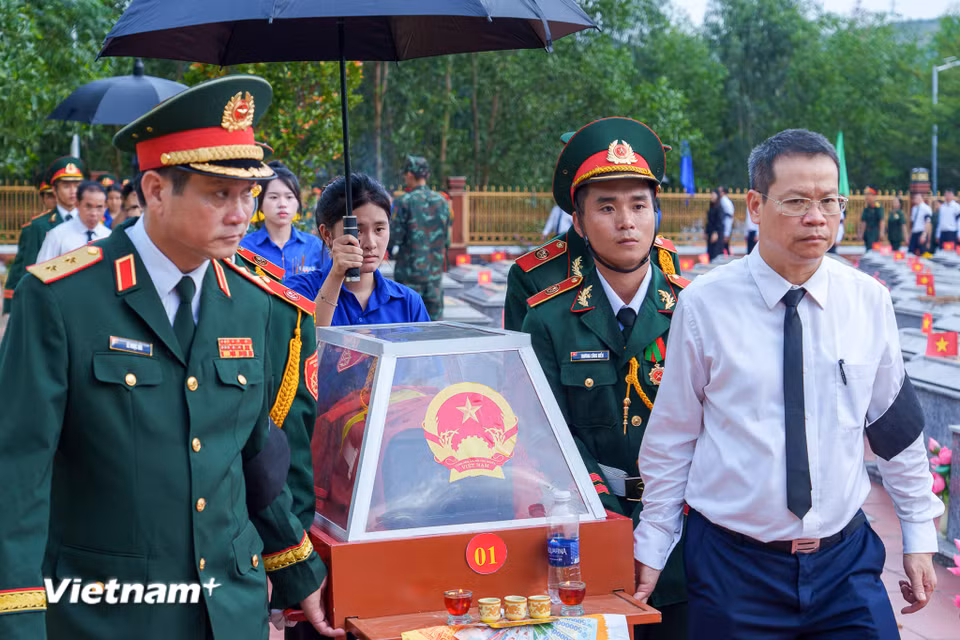 Trung tướng Lê Ngọc Hải (hàng đầu, bên trái), Ủy viên Trung ương Đảng, Tư lệnh Quân khu 5 cùng Phó Bí thư Thành ủy, Chủ tịch Ủy ban nhân dân thành phố Nguyễn Mạnh Hùng (áo trắng, bên phải) cẩn thận đưa hài cốt các liệt sĩ về nơi yên nghỉ. (Ảnh: Thanh Phong/Vietnam+)