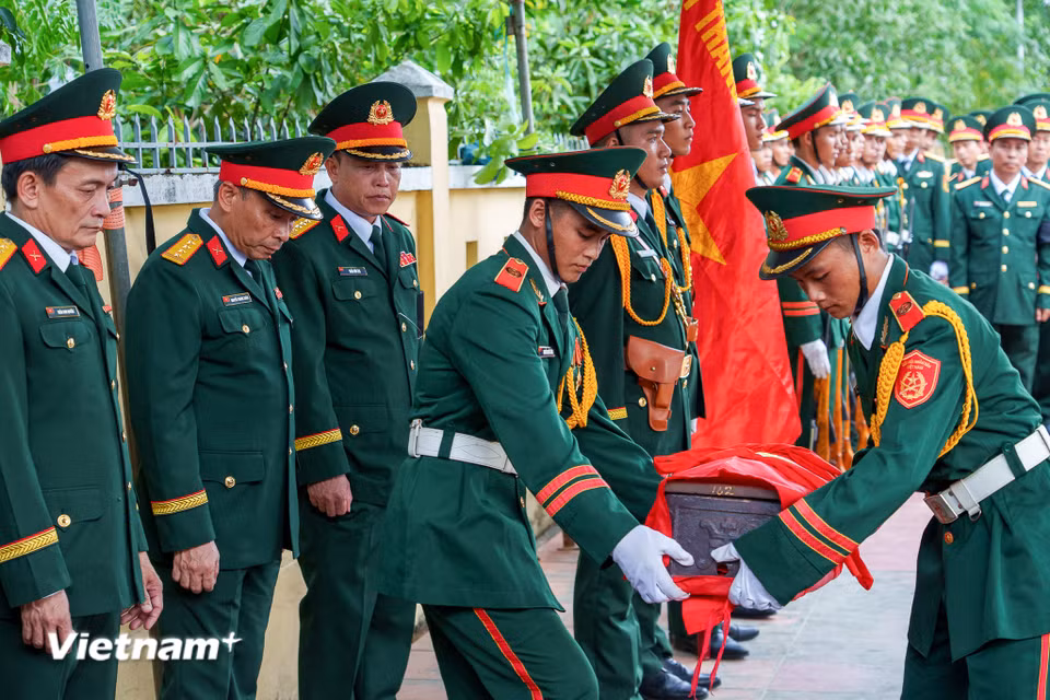Đội tiêu binh cẩn trọng đưa hài cốt các liệt sĩ về nơi yên nghỉ. (Ảnh: Thanh Phong/Vietnam+)