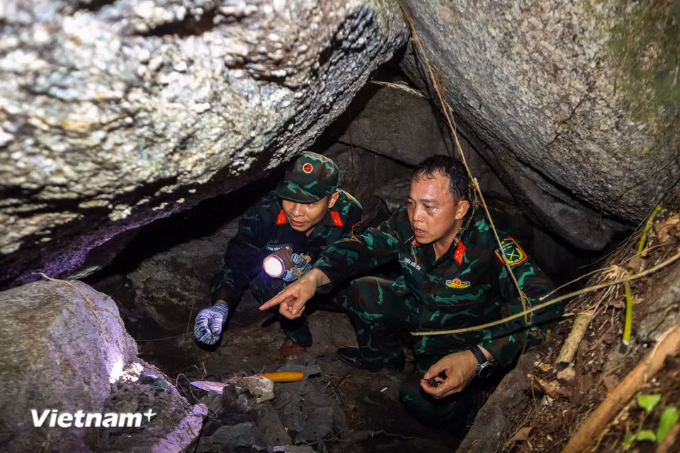 Lực lượng tìm kiếm phải chui vào những hốc sâu chật hẹp, len lỏi qua các khối đá khổng lồ xếp chồng lên nhau. (Ảnh: Thanh Phong - Quang Cường/Vietnam+)