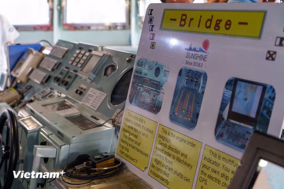 Khu vực buồng lái (Bridge) của tàu Asahi. Bảng thông tin giới thiệu chi tiết về hệ thống điều khiển bánh lái tay, tay chuông truyền lệnh buồng máy và màn hình hải đồ điện tử hiển thị GPS. (Ảnh: Thanh Phong/Vietnam+)