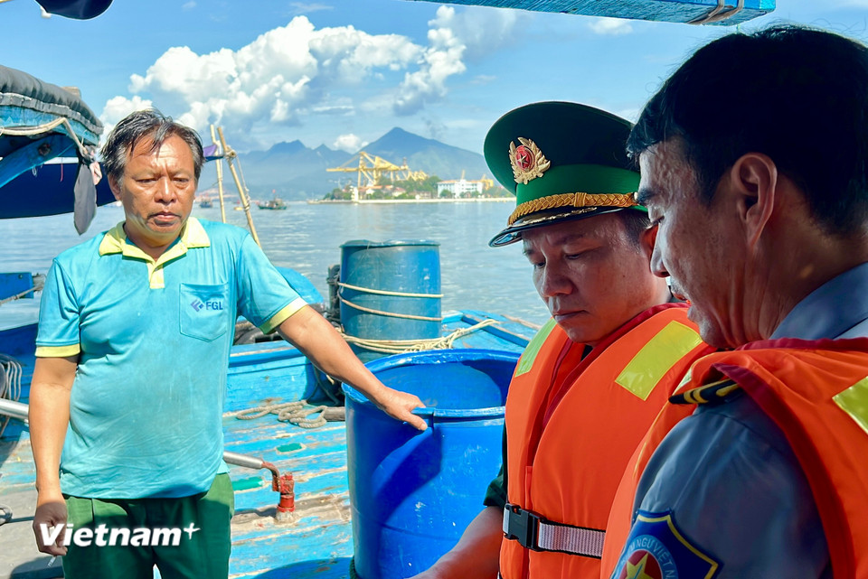 Bộ đội Biên phòng phối hợp Chi cục Biển đảo và Thủy sản kiểm tra nhật ký và các giấy tờ cần thiết của 1 tàu cá đang hoạt động trên biển. (Ảnh: Thanh Phong/Vietnam+)