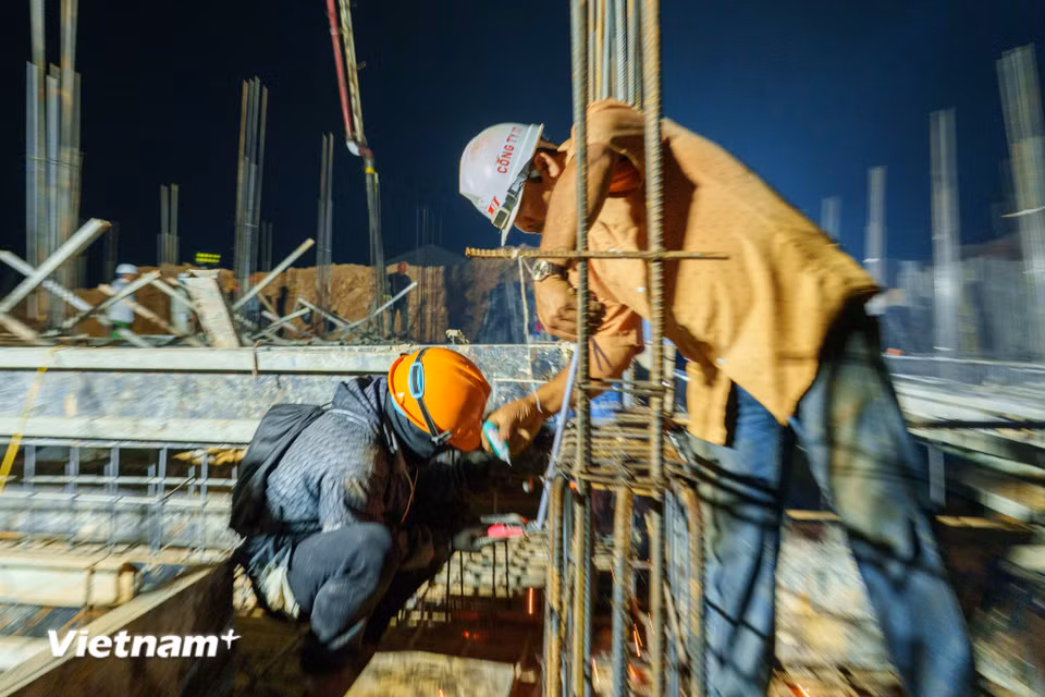 Vừa hàn vừa đánh dấu vị trí cần hàn, hoạt động thi công phối hợp nhịp nhàng. (Ảnh: Thanh Phong/Vietnam+)
