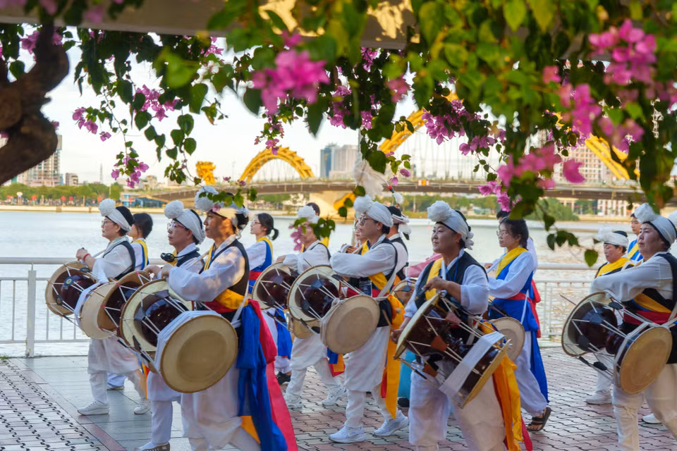 Đoàn diễu hành rực rỡ sắc màu với các nghệ sĩ biểu diễn nhạc cụ truyền thống Hàn Quốc nổi bật dưới vòm hoa giấy bên bờ sông Hàn. (Ảnh: Thanh Phong/Vietnam+)