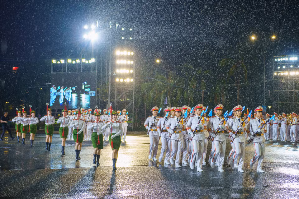 Khối quân nhạc biểu diễn các giai điệu hào hùng cùng những bước đi nhịp nhàng, đều tắp trong màn mưa lớn thu hút sự chú ý của khán đài. (Ảnh: Thanh Phong/Vietnam+)