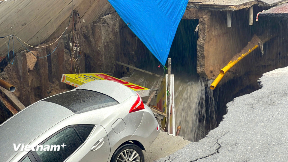 Theo ghi nhận của phóng viên, ở thời điểm tiếp cận hiện trường phố Nguyễn Công Trứ, có hai ô tô con đang đỗ sát lề đường bị rơi xuống hố, một ôtô con khác nằm vắt vẻo trên miệng hố. (Ảnh: Thanh Phong/Vietnam+)