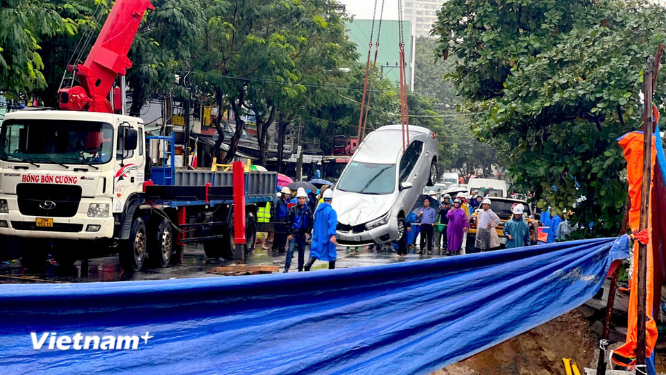 Ôtô rơi xuống 'hố tử thần' đã được đội cứu hộ cẩu lên. (Ảnh: Thanh Phong/Vietnam+)
