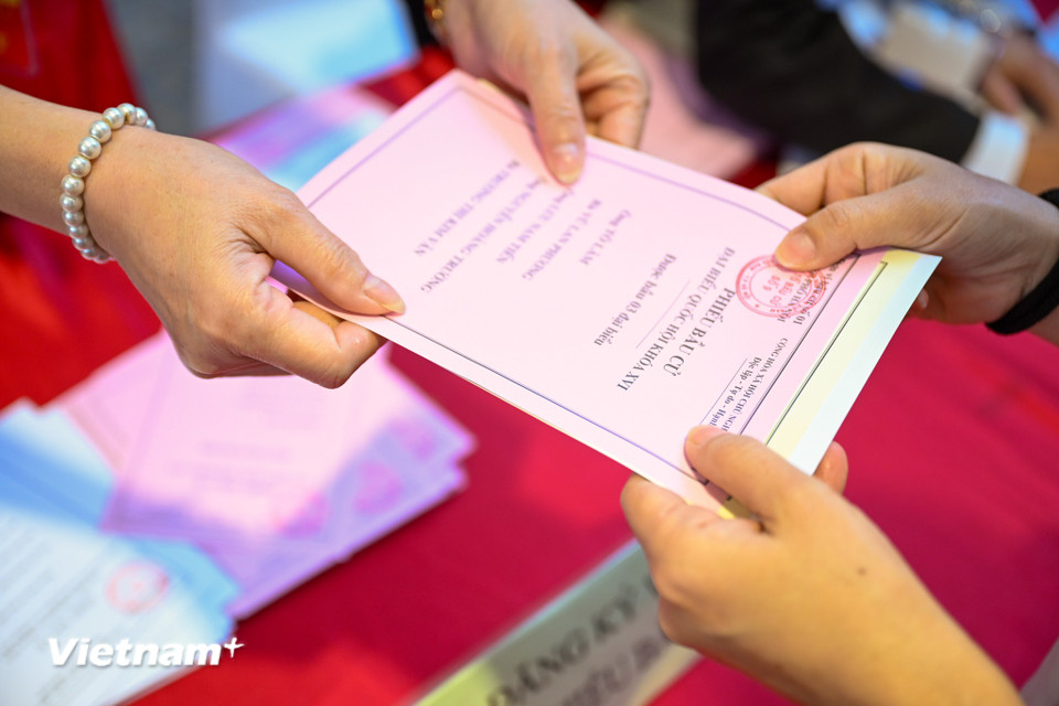 Đúng 7 giờ sáng, những lá phiếu đầu tiên của cử tri Thủ đô đã được trang trọng bỏ vào hòm phiếu, chính thức mở đầu cho ngày bầu cử đầy ý nghĩa. (Ảnh: Minh Sơn/Vietnam+)