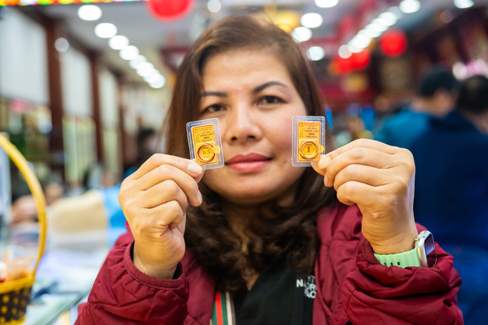 Chị Lê Thúy Hằng, một trong những khách hàng đầu tiên mua vàng tại Bảo Tín Minh Châu hào hứng chia sẻ: 'Năm nào mình cũng tranh thủ xếp hàng từ sớm để mua một vài chỉ vàng cho mình và con gái để lấy may đầu năm.' Chị Hằng cũng cho biết việc mua vàng bằng máy tự động giúp quy trình nhanh chóng, không phải chờ đợi lâu. (Ảnh: Minh Sơn/Vietnam+)
