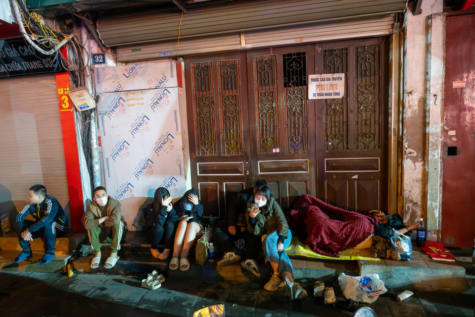 Rạng sáng 26/2 (mùng 10 tháng Giêng), dù mưa phùn và trời rét, nhiều người đã xếp hàng trước các cửa hàng vàng bạc trên phố Trần Nhân Tông (Hà Nội) chờ mua vàng trong ngày vía Thần Tài. (Ảnh: Minh Sơn/Vietnam+)