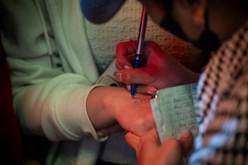 Theo ghi nhận, trời chưa sáng hẳn, vỉa hè phố Trần Nhân Tông - nơi có nhiều cửa hàng vàng đã chật kín người. Không ít người tay xách ghế nhựa, áo mưa quấn kín, kiên nhẫn xếp số thứ tự chờ đến giờ mở cửa. (Ảnh: Minh Sơn/Vietnam+)