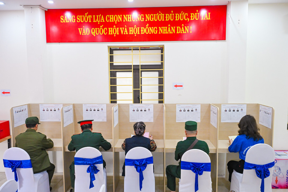 Trước khi bỏ phiếu, cử tri kiểm tra lại thông tin trên phiếu bầu và danh sách người ứng cử được niêm yết tại khu vực bỏ phiếu. (Ảnh: Minh Sơn/Vietnam+)