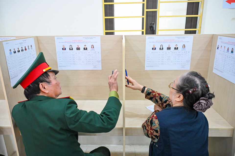 Trước khi bỏ phiếu, cử tri kiểm tra lại thông tin trên phiếu bầu và danh sách người ứng cử được niêm yết tại khu vực bỏ phiếu. (Ảnh: Minh Sơn/Vietnam+)