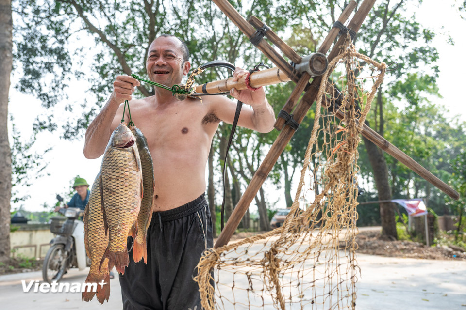 Một buổi dập sào kết thúc, gần như ai cũng được 1 xâu cá nặng xách về. (Ảnh: Minh Sơn/Vietnam+)