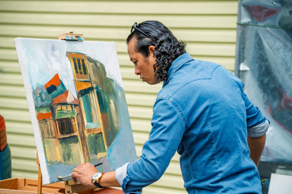 Một họa sỹ tranh thủ lưu lại những nét vẽ trong một góc phố cổ. (Ảnh: Minh Sơn/Vietnam+)