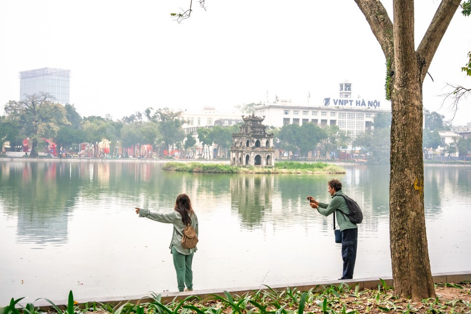 Những vị khách du lịch quốc tế dường như cũng cảm nhận một Hà Nội rất khác trong sáng Mùng 1 Tết. (Ảnh: Minh Sơn/Vietnam+)