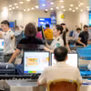 Nhân viên an ninh hàng không tại Sân bay Quốc tế Nội Bài kiểm tra hành khách qua cửa soi chiếu. (Ảnh: PV/Vietnam+)