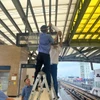 Nhân viên Hà Nội Metro che chắn bảng điện tử tại một sân ga của tuyến đường sắt đô thị Cát Linh-Hà Đông. (Ảnh: PV/Vietnam+)
