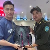 Nhân viên Sân bay Nội Bài hỗ trợ khách Trung Quốc tìm lại tài sản bỏ quên trên xe taxi. (Ảnh: PV/Vietnam+)