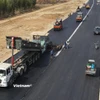Nhà thầu thi công thảm nhựa nền đường một Dự án đường bộ cao tốc Bắc-Nam phía Đông. (Ảnh: Việt Hùng/Vietnam+)