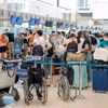 Hành khách làm thủ tục đi máy bay tại Cảng hàng không Quốc tế Nội Bài. (Ảnh: PV/Vietnam+)
