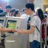 Nhân viên an ninh hàng không kiểm tra giấy tờ hành khách làm thủ tục đi máy bay tại Cảng Hàng không quốc tế Nội Bài. (Ảnh: PV/Vietnam+)