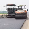 Nhà thầu thi công thảm bê tông nhựa một dự án đường bộ. (Ảnh: Việt Hùng/Vietnam+)