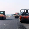 Nhà thầu thi công thảm nhựa mặt đường một dự án thành phần cao tốc. (Ảnh: Việt Hùng/Vietnam+)