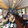 Những hành khách đầu tiên tham gia trải nghiệm toa hạng sang trên đoàn tàu Hoa Phượng đỏ. (Ảnh: Việt Hùng/Vietnam+)