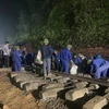 Công nhân viên ngành Đường sắt xuyên đêm cứu hộ tàu hàng trật bánh và bị lật nghiêng sau vụ va chạm với xe tải tại Hà Tĩnh. (Ảnh: PV/Vietnam+)